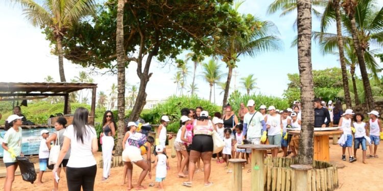 Crianças participam de mutirão de limpeza na praia de Stella Maris e acompanham soltura de tartarugas