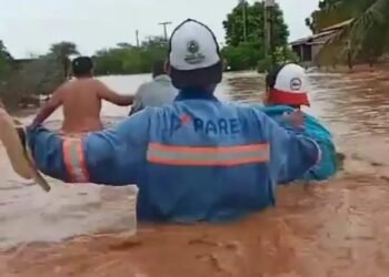 Imagens mostram moradores tentando atravessar uma faixa da rua completamente sob água - Foto: Reprodução | Twitter