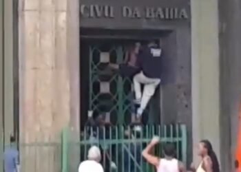 Policial tenta tirar homem do portão Crédito: Leitor Correio